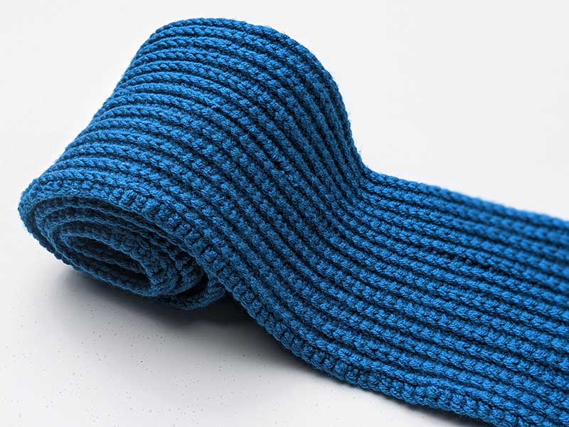 rolled up blue crochet scarf