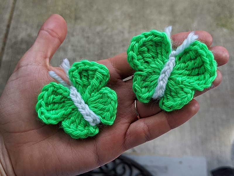 two crochet green butterflies with white antennas