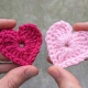two tiny crochet hearts - one red and one pink coloured