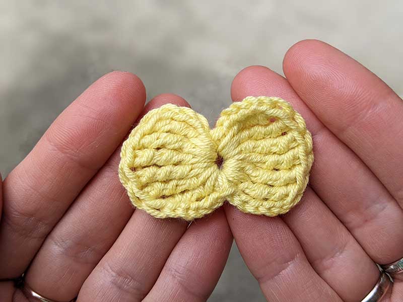 crochet tiny bow made with yellow yarn