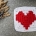 crochet granny square with red heart and white canvas