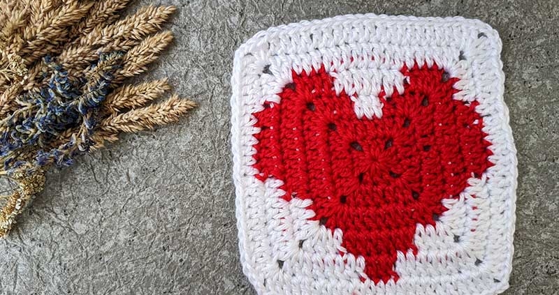 crochet granny square with red heart and white canvas