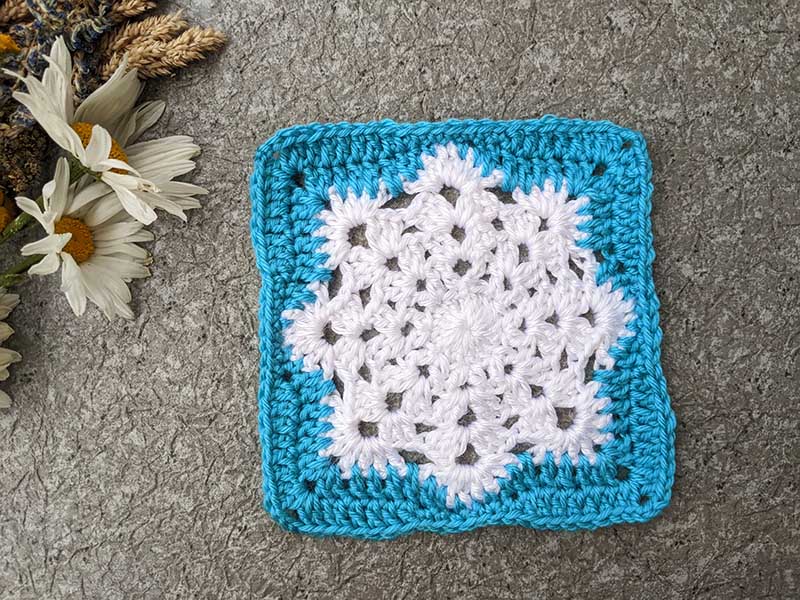 crochet snowflake granny square pattern - white snowflake and blue edges