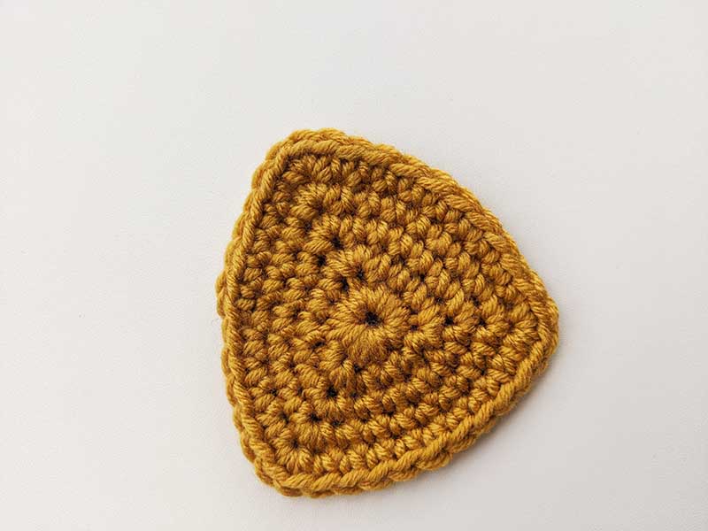 crochet pattern of a triangle with equal sides made in the round