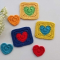 three crochet solid heart granny squares and three crochet hearts arranged in a composition