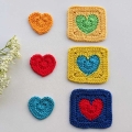 three crochet solid heart granny squares arranged vertically - green & orange, blue & yellow, and red & navy bue