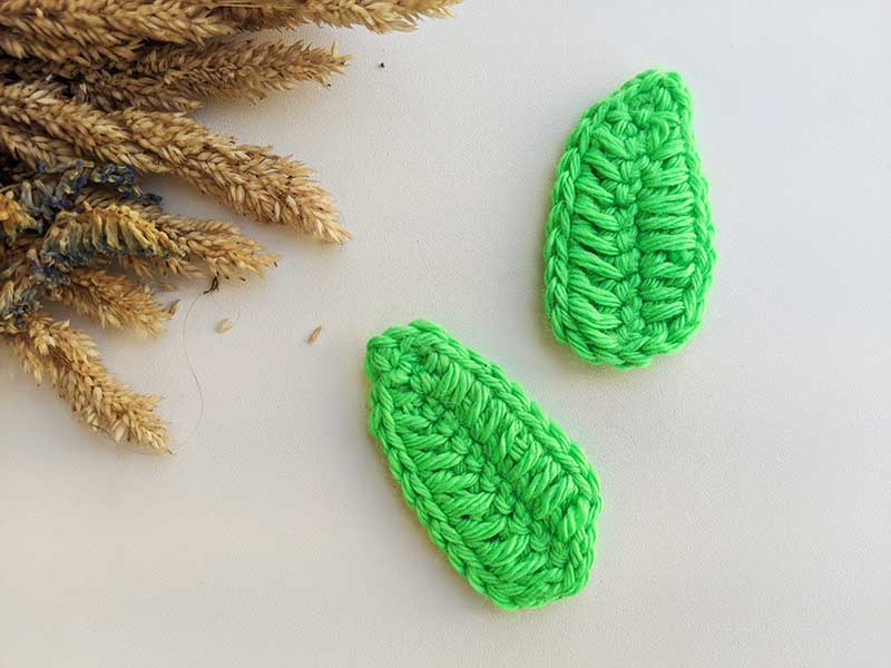 two crochet green feather leaves