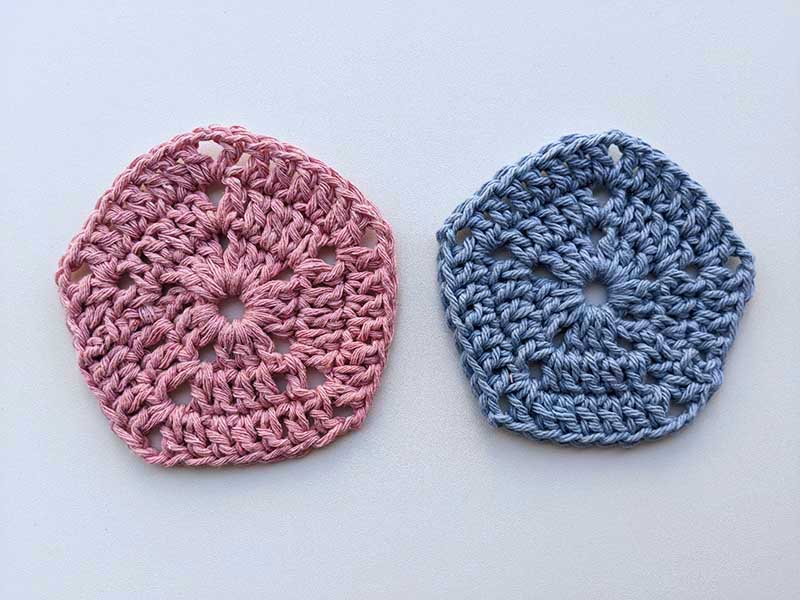 two crochet pentagons, one blue and one pink, made using double crochet stitch