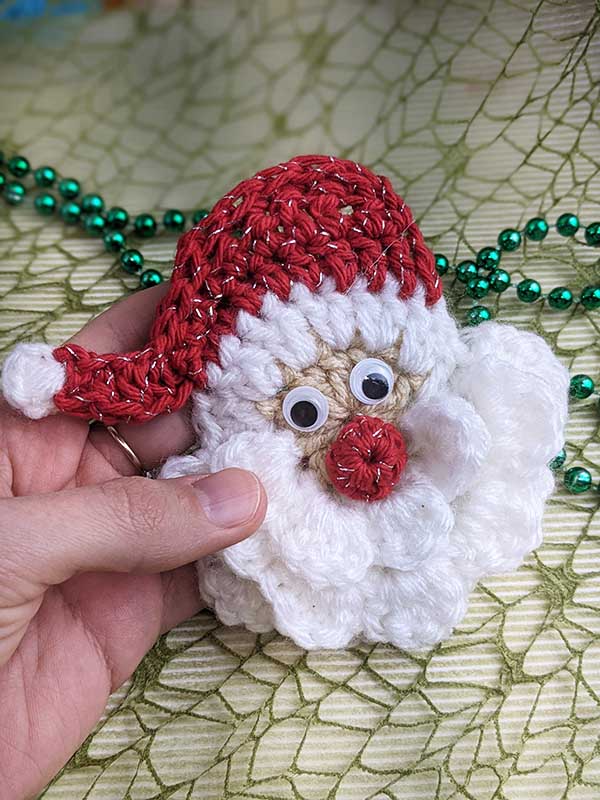 crochet Santa head with red hat, white beard, red nose and glued eyes