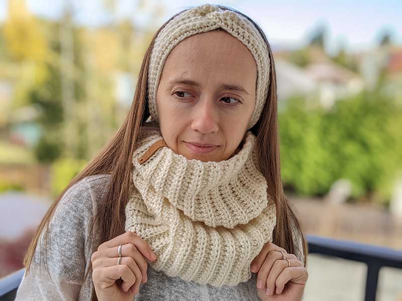 female model wears crochet twisted ear warmer and matching crochet cowl