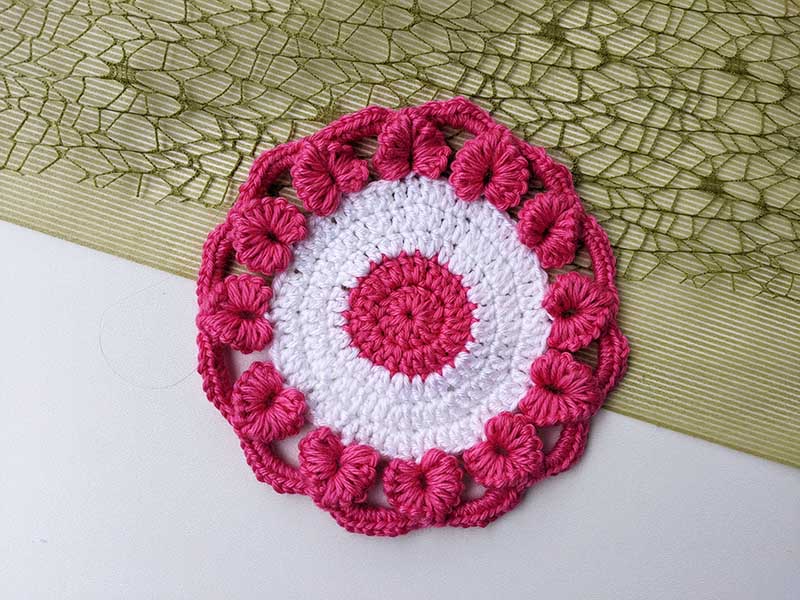 pink and white crochet round coaster with hearts