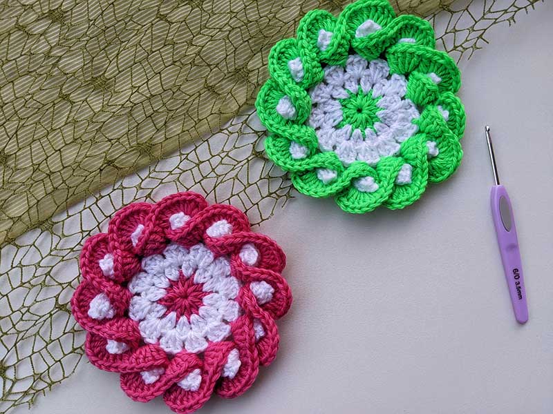 two crochet flower coasters - one green and one red