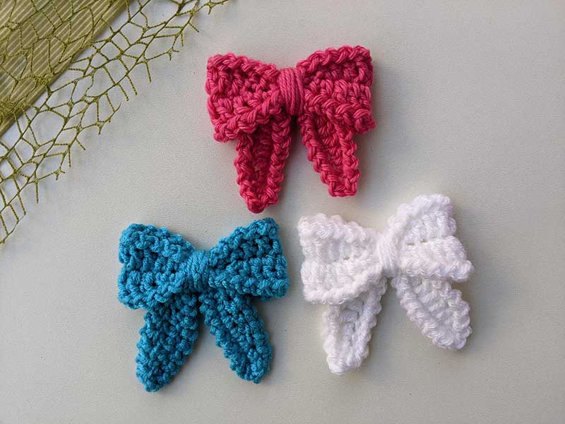 three crochet hair bows in different colors