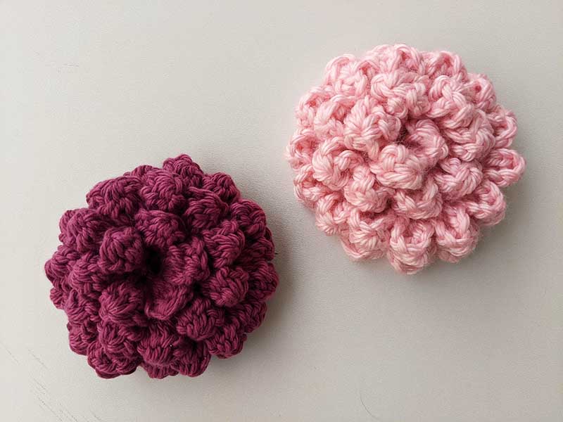 two chunky crochet peony flowers - one made with violet and another one with pink color yarn