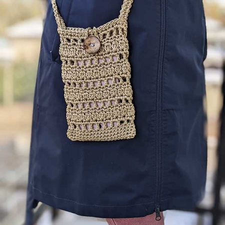 female model wears a crochet cellphone bag on a long handle