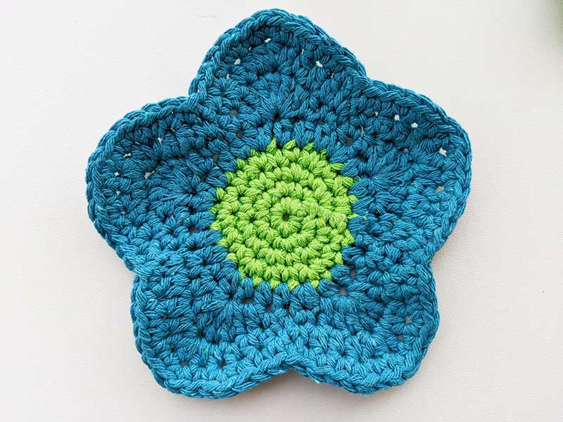 crochet blue flower with big petals and green seed