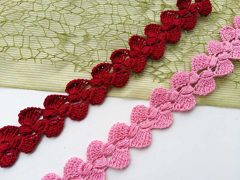 two crochet laces made in different colors - one pink and one red