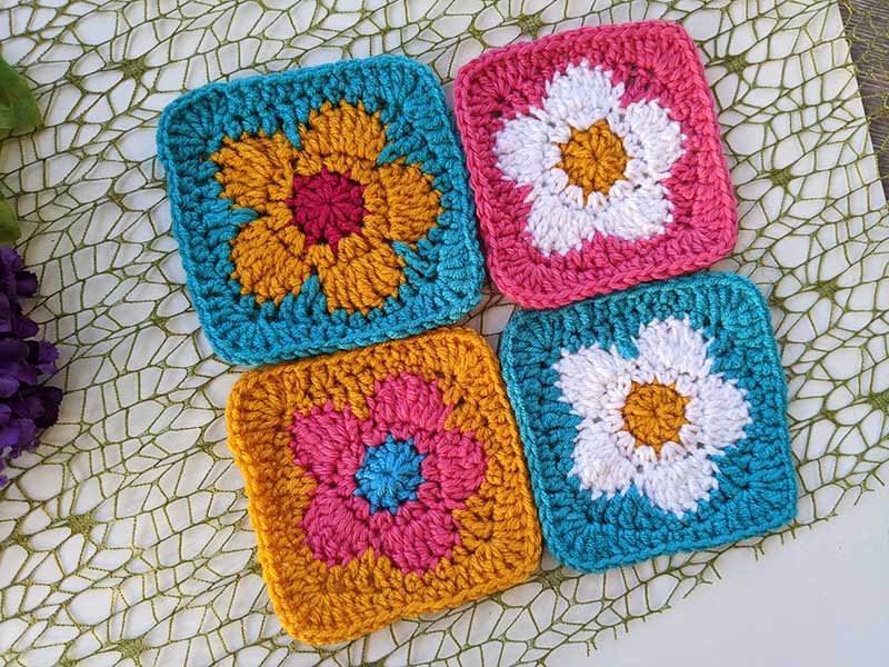 four crochet daisy flower granny squares arranged in a bigger sized square