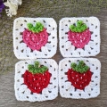 four crochet strawberry granny squares arranged in a bigger-sized square
