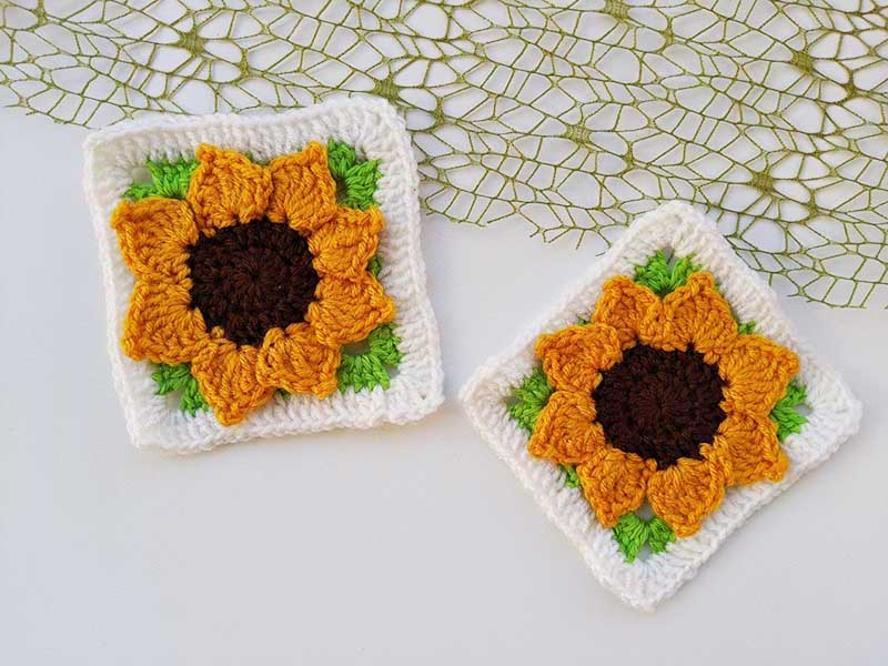 two crochet three-dimensional sunflower granny squares laying next to each other