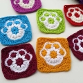 seven crochet dog paw print granny squares made in different colors - light blue, purple, yellow, light green, pink, violet, and red