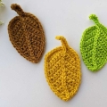 three crochet autumn fall leaves arrangement made with one brown, one yellow, and one green leaf