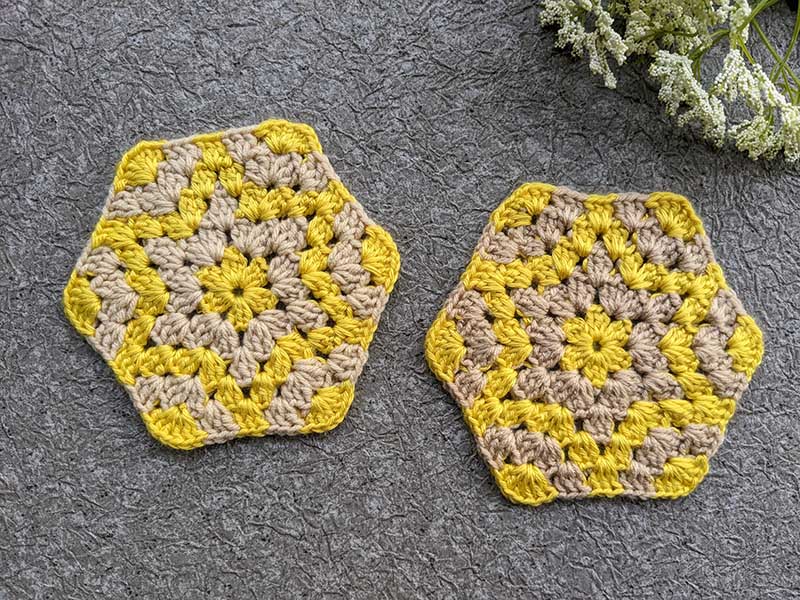 two crochet hexagon-shaped coasters with embedded six-point stars