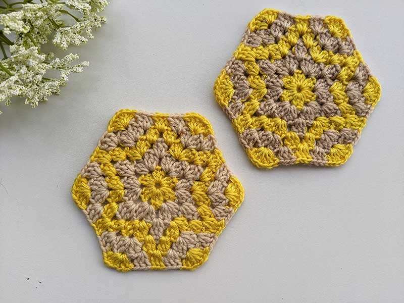 two crochet hexagon coasters with stars