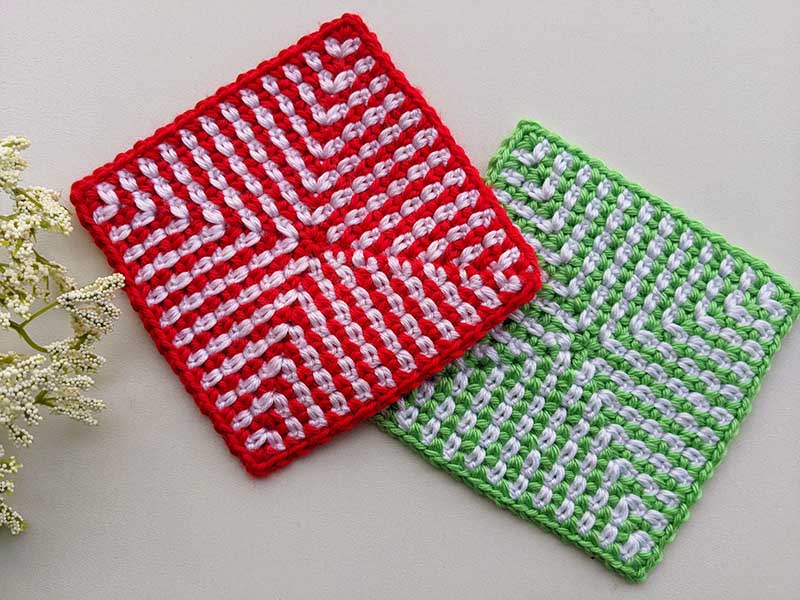 two crochet moss stitch granny squares - one red and another one green with white background