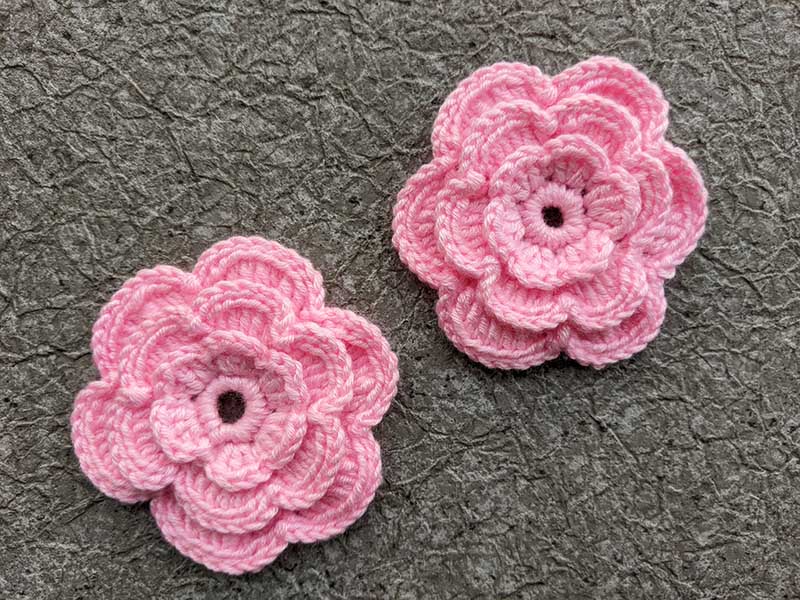 two crochet pink triple-layer flowers