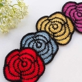 four crochet roses arranged in a diagonal line