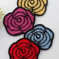 four crochet two-color roses arranged vertically