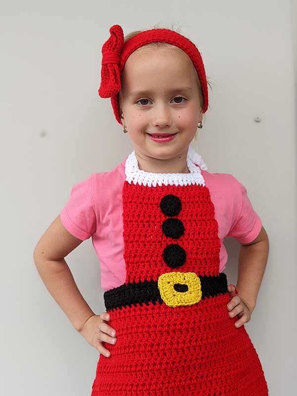 crochet Christmas headband and apron set on a kid model - close-up view