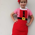 crochet Christmas headband and apron set on a kid model - zoomed-out view