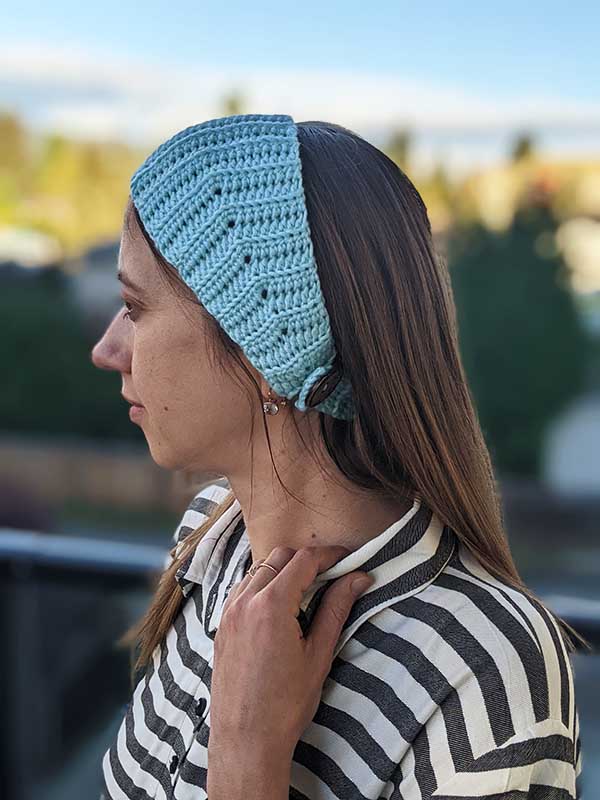 crochet headband with button closure on a female model