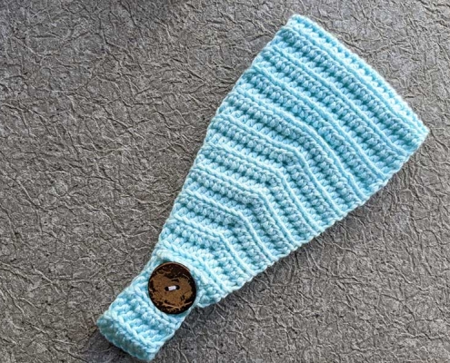 crochet pattern of a headband with button closure