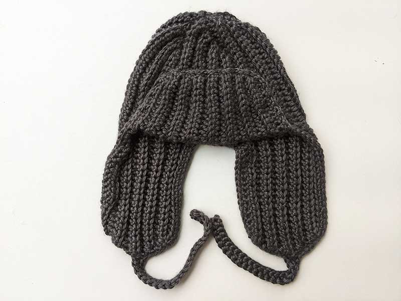 crochet trapper hat for men and women - front view on a flat surface