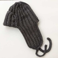 crochet trapper hat for men and women - side view on a flat surface