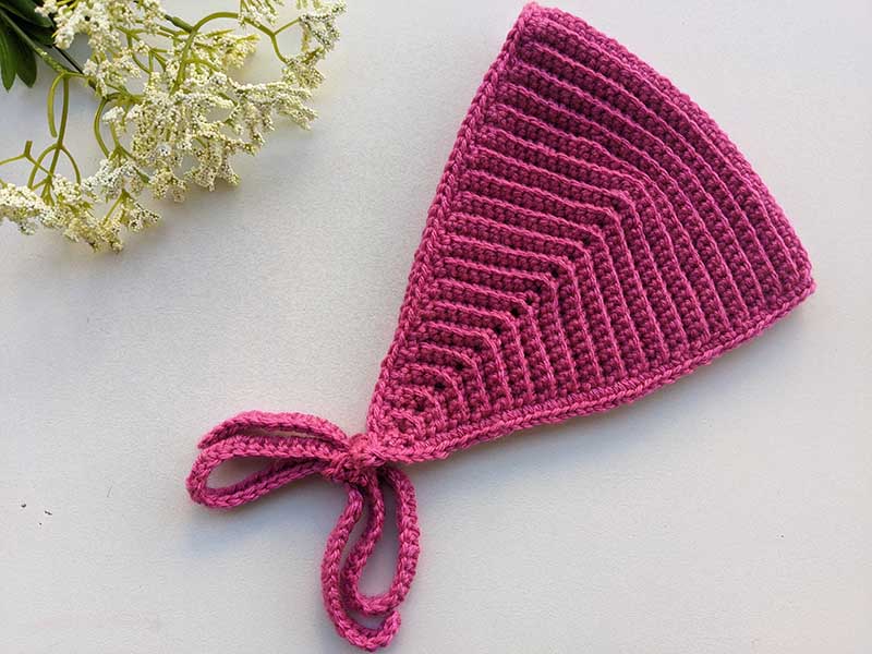 crochet bandana with ties on a flat surface