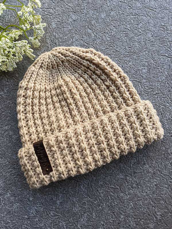 crochet flat unisex hat on a flat surface