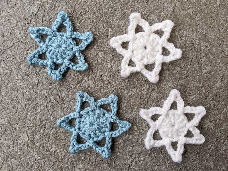 four Christmas star snowflakes - two white and two blue side-by-side