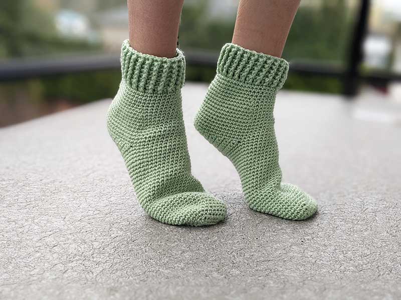 crochet beginner-level socks on female feet