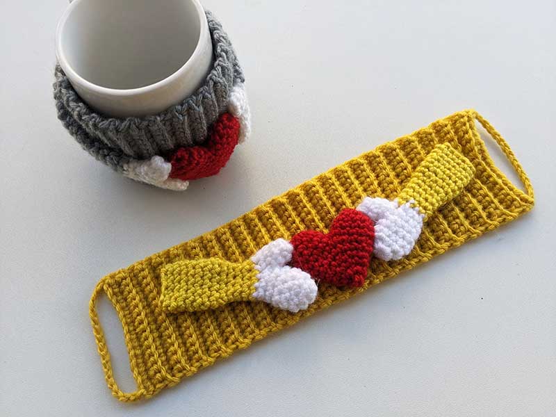 crochet cup cozy with a heart made in different colors