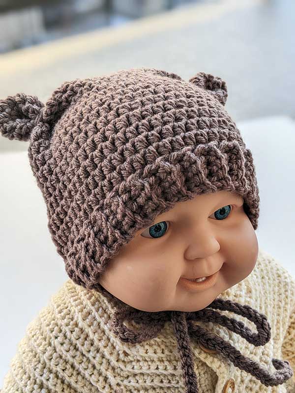 crochet teddy bear hat on a baby doll