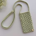 crochet smartphone shoulder bag with a shell stitch texture shot on a flat surface