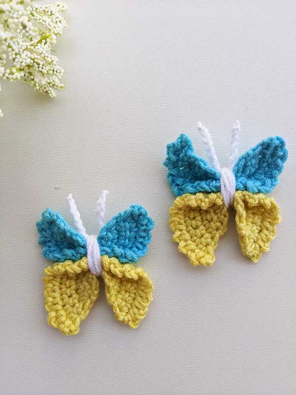 two crochet decor butterflies next to each other made in the colors of Ukrainian or Swedish flag