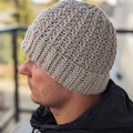 crochet modern textured hat on male model - left side view