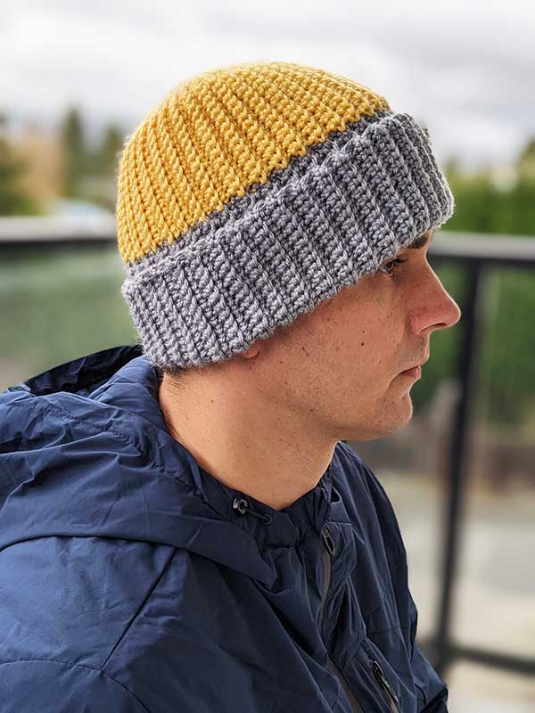 crochet two-color hat on a male model - right side view