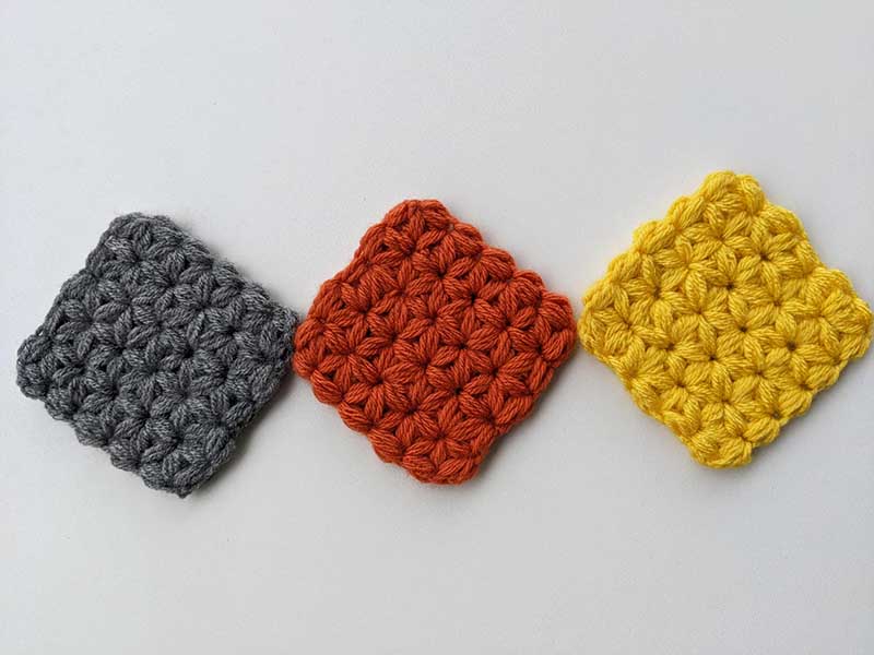 three crochet jasmine stitch coasters arranged in a straight line