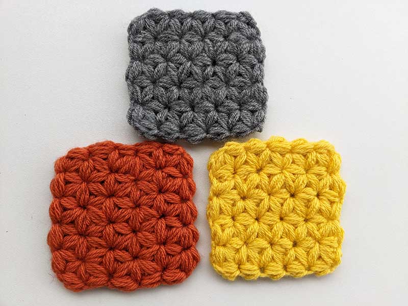 three crochet jasmine stitch coasters arranged in a triangle